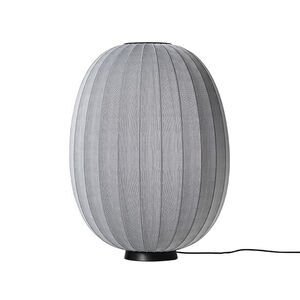 Oval lampe med grå strikket overflade, sort base og ledning til højre.
